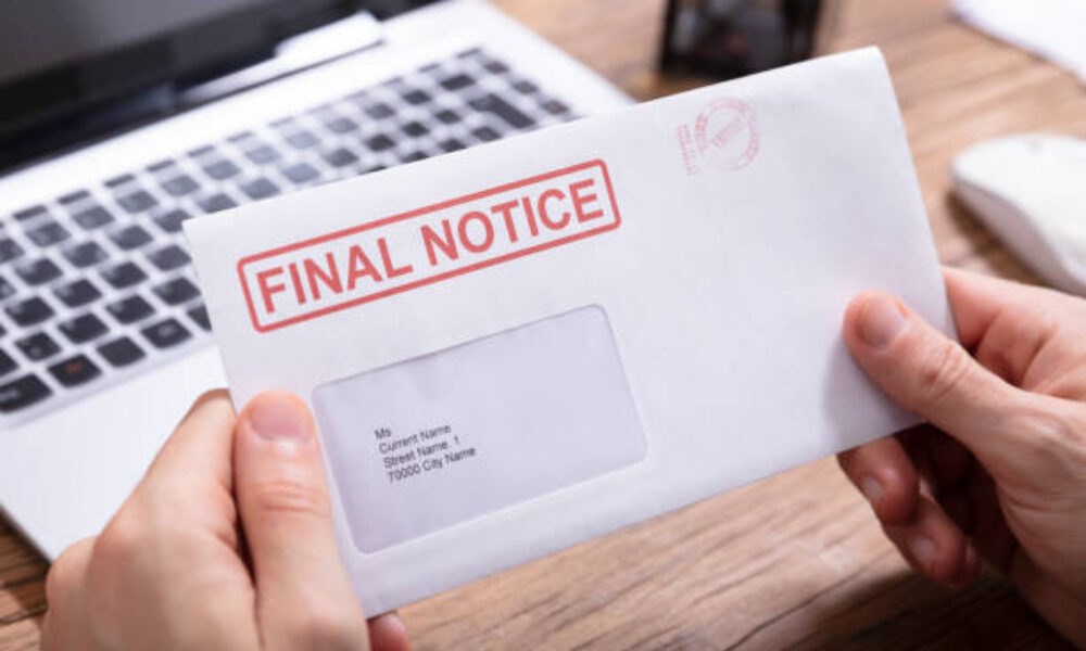 Close-up Of Person's Hand Holding Final Notice Envelope